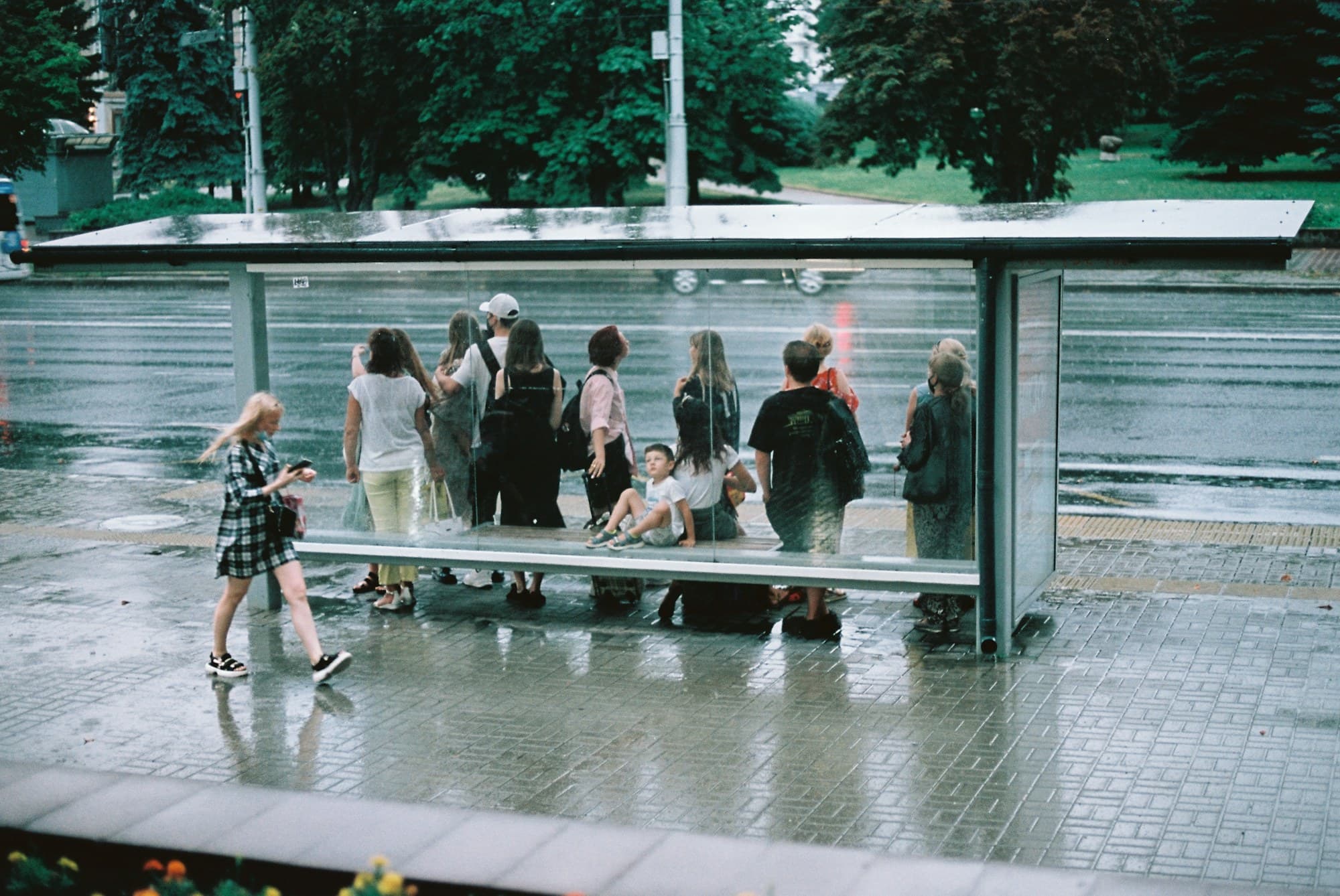 People waiting together at a glass bus shelter