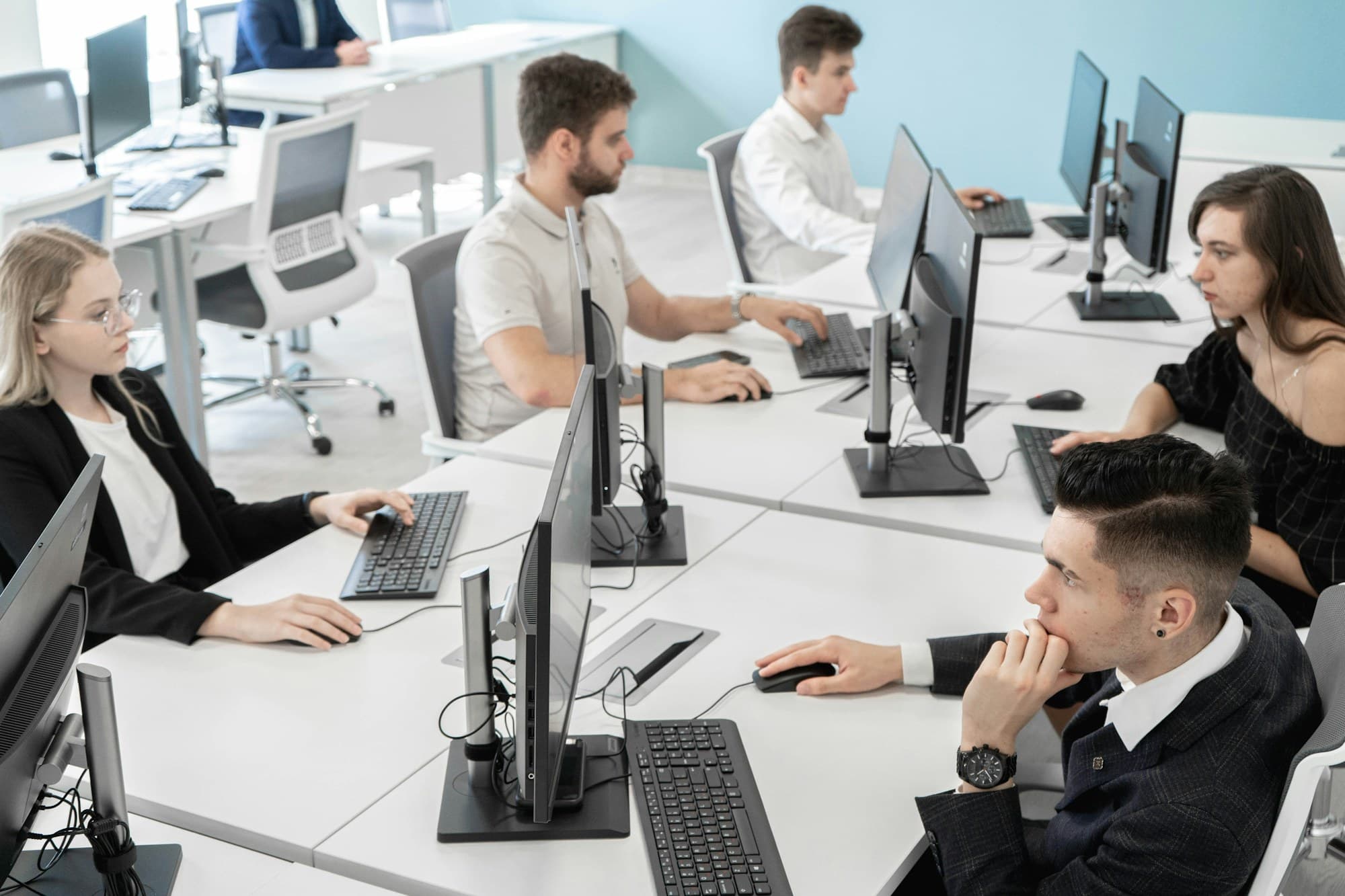 Young adults working at computers in a bright open workspace